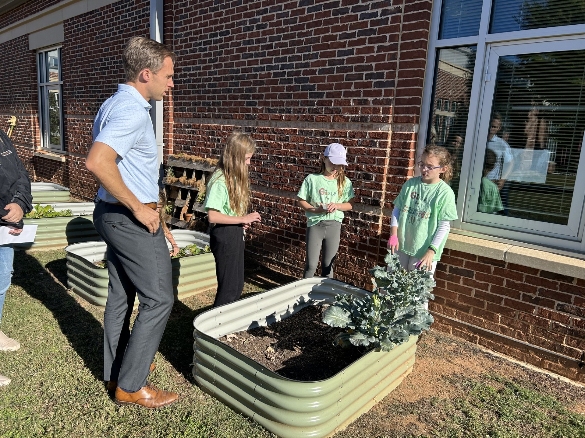 Girls showing Mayor the garden beds