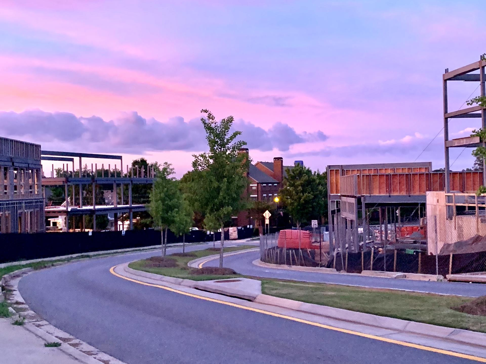 Photo of downtown Milton, also known as Crabapple, from Heritage Walk with construction and a pink and purple sky in the background 